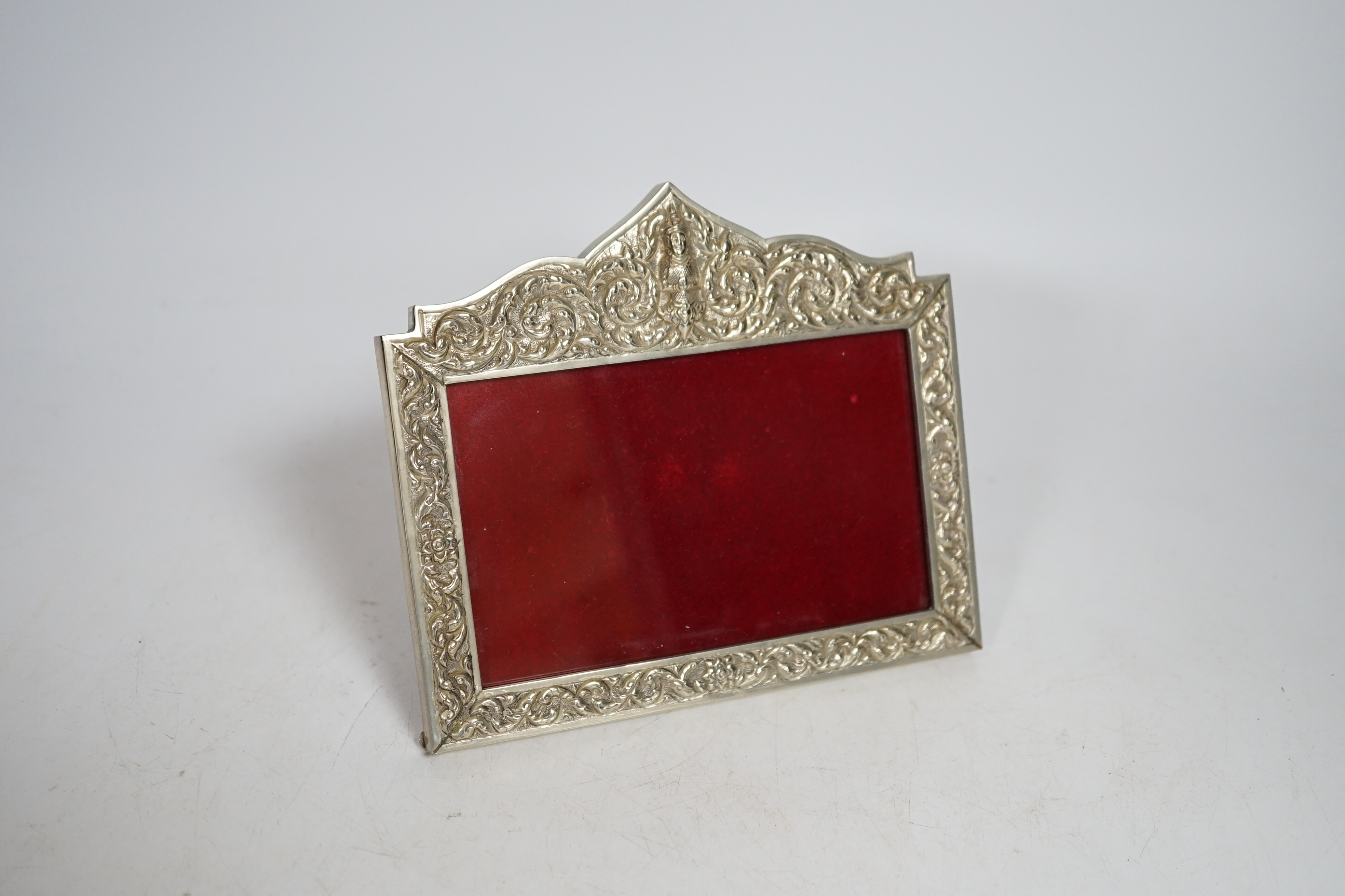 A Thai white metal cigarette box, stamped sterling, 14cm, and a similar sterling overlaid photograph frame, width 16cm